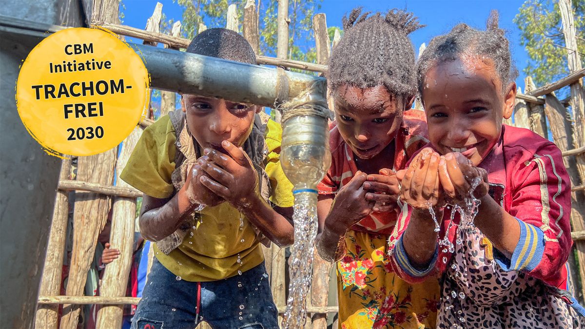 Auf einem Laster steht eine meterhohes Bohrgerät. Männer stehen an dem Gerät, das sich in den Boden schraubt. Auf einem gelben Punkt steht: CBM-Initiative TRACHOMFREI 2030
