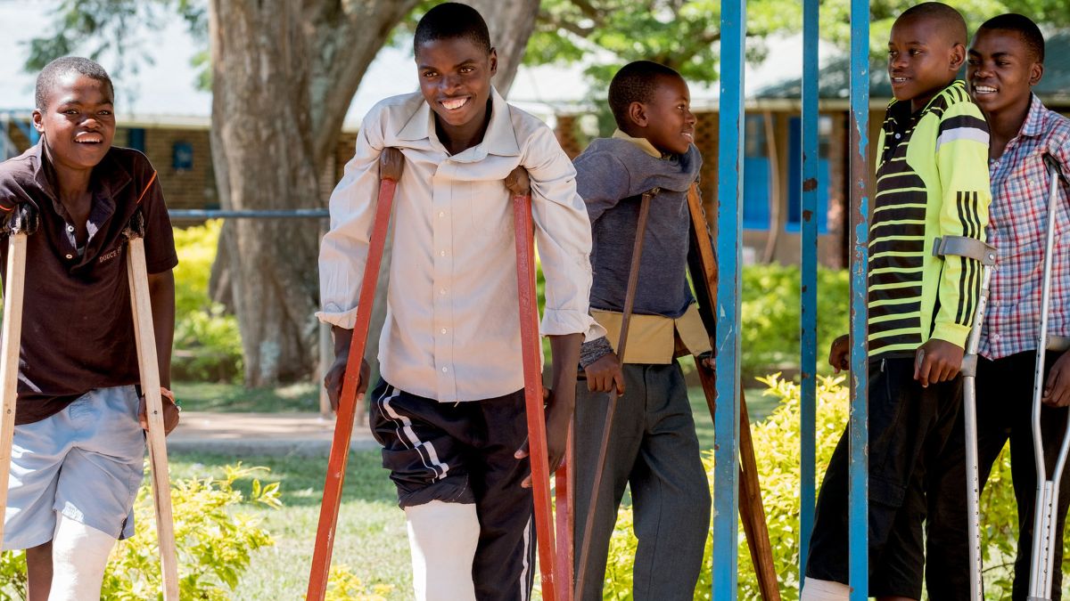 Afrikanische Jungen mit Gips und Krücken.