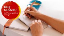 Eine Hand hält einen Stift und schreibt auf einen Block, der auf einer Kladde liegt, daneben steht eine Kaffeetasse.