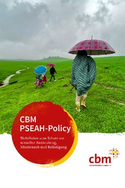 Personen mit Regenschirm gehen auf einer gründen Wiese, auf einem roten Punkt die Schrift:  CBM PSEAH-Policy.