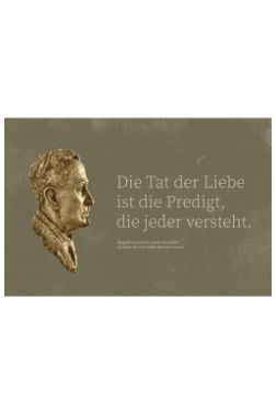 Bronzebüste, daneben der Schriftzug: Die Tat der Liebe ist die Predigt, die jeder versteht.