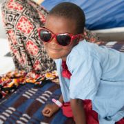 Kleines Mädchen mit roter Sonnenbrille