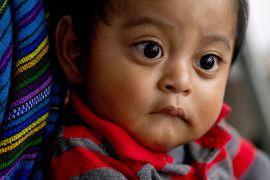 Etwa neun Monate altes Baby mit großen dunklen Augen.