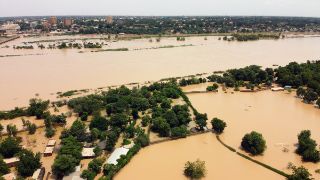 Lufftbild einer überschwemmten Landschaft, Hausdächer schauen aus dem Wasser