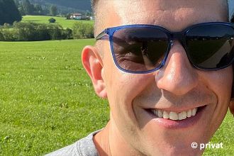Lachender junger Mann mit Sonnenbrille.