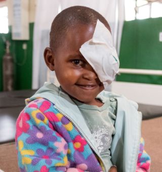 Afrikanisches Kind mit Augenverband