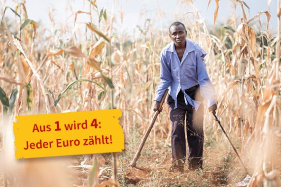Ein Mann geht an Krücken zwischen Maispflanzen hindurch. Text auf dem Bild: Aus 1 wird 4. Jeder Euro zählt!