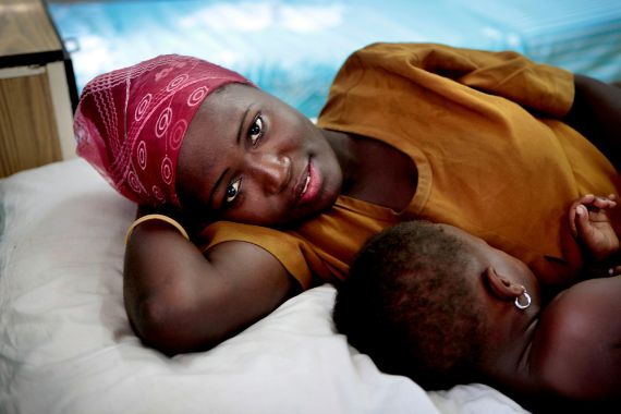 Afrikanische Frau liegt mit ihrem Kind in einem Krankenhausbett