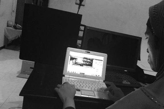 Eine Frau blickt konzentriert auf den Bildschirm eines Laptops.