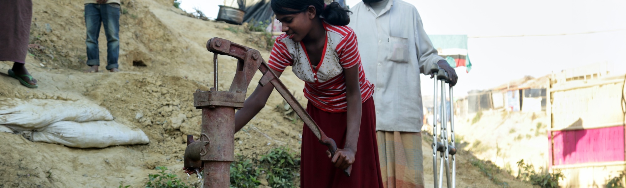 Ein Mädchen wäscht sich die Hände an einem Wasserhahn.